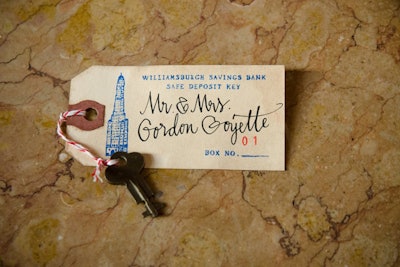Guests grabbed calligraphed escort cards that were attached to vintage safety-deposit-box-inspired keys at a bank-theme wedding, which was held at Skylight One Hanson in the former Williamsburgh Savings Bank clock tower in Brooklyn and produced by Brilliant Event Planning.