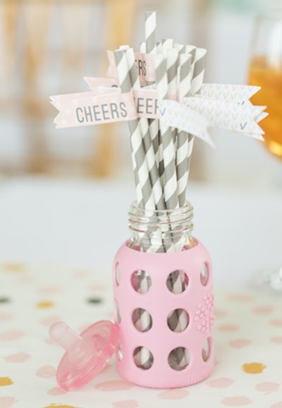 An example of a baby-theme catering presentation: New York-based event firm Rock Paper Scissors Events recently housed striped straws in baby bottles.