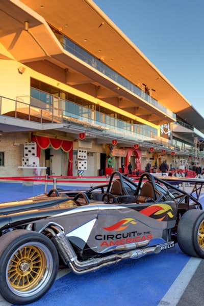 A two-seat sports car adorned with the racetrack logo was parked at the party.