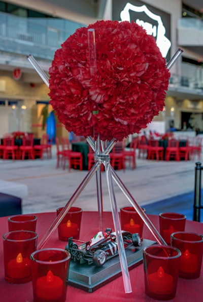Table decor featured red, black, and gray hues, as well as mini race cars and vibrant floral arrangements by David Kurio Designs.