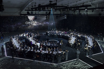 Bureau Betak transformed the Western Airways Hangar into a spectacular 20,000-square-foot party setting—the Omega Lunar Base—that flowed from the 'space capsule' into a dramatic moonscape, where dinner was served beneath a starlit orb.