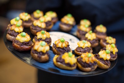 Tender, smoky braised short ribs served inside mini roasted potatoes and topped with potato puree and brown-buttered peas, by Truffleberry Market in Chicago