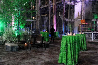 Bathed in green light, live trees and plants filled the industrial venue.