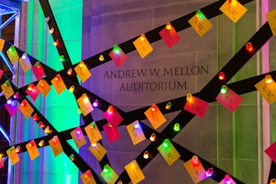 Escort cards, which were tacked to a crisscrossed black wood fixture at the entrance, were lit up by colorful rings that blinked the entire night.