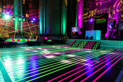 Inspired by an image of laser lighting, Evoke's design team used neon green and pink tape to turn the dance floor into the event's laser-esque focal point.