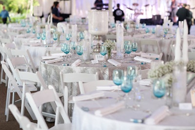 'The dinner tables were dressed in a combination of white textured linens and silver birch linens to provide a polar-landscape-inspired foundation,' Hensel said. Tabletop decor also included hand-carved 'icebergs,' iced-glass hurricanes, aluminum vases, and tall iced-glass cylinders. Hall's Rentals provided ice-blue wine glasses, and a box of Altoids at each place setting made for a thematic gift.