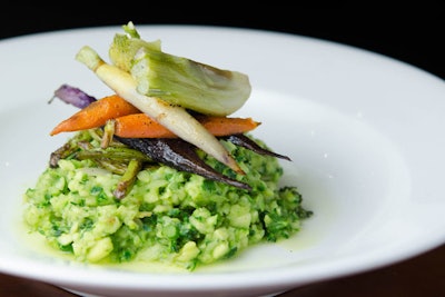 Springtime risotto made of minced zucchini and broccolini “rice,” served with green pea and lemon sauce, fiddlehead ferns, tricolor baby carrots, and baby fennel, by Blossom in New York