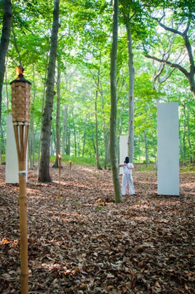 As guests made their way through the entranceway of bamboo, to their immediate right they found Ann Mirjam Vaikla's 'Silencium' installation: a performance in which masked figures in white cotton wielded sledgehammers against monoliths set in the woods. Periodically, the figures lit smoke bombs that were thrown into the monoliths. With each blow of the sledgehammer, the masked figures froze.