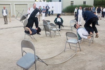 Within the main central courtyard of the center, where guests converged following their walkthrough of the art installations in the forest, was Jack Pavlik's 'Zero Sum Sitting' artwork. The United States artist presented a series of kinetic steel sculptures—folding chairs attached to which performers interacted on the west terrace.