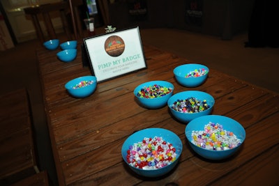 Evoking a craft station at a kids’ camp, organizers invited guests to decorate their name badges with colored beads.