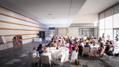 Natural light fills the Herscher Hall atrium during a networking breakfast. Photo by Bebe Jacobs.