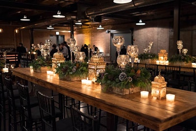The seasonal greenery also appeared as table decor, along with lanterns and goblet-style votive candlesticks, complementing the rustic vibe of the dining space.