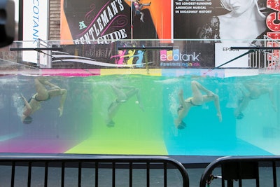 The 17,000-gallon swim tank was designed with the ink cartridge colors of magenta, yellow, and cyan. The swimmers performed original routines choreographed by Stephan Miermont, owner of water show production company Aquartist.