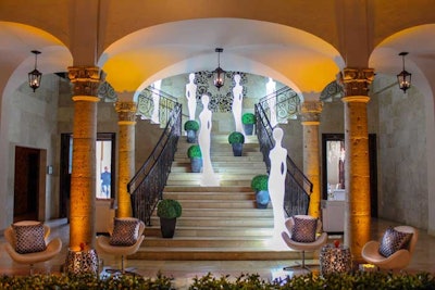 Draw attention to a staircase with beautiful Penelope Lights and greenery.