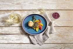 A plated appetizer of seared scallop with citrus and Merlot salt.