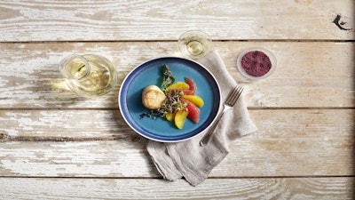 A plated appetizer of seared scallop with citrus and Merlot salt.