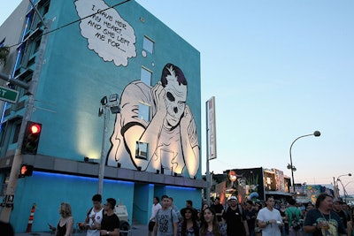 A large-scale artwork on a building façade by street artist D*Face, originally created for the festival's inaugural year, towered over attendees.