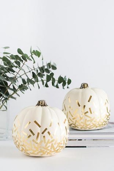 Gold confetti pumpkins from Homey Oh My only require three supplies—a pumpkin, scissors, and Washi tape.
