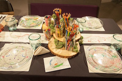 More doodling was encouraged at the table designed by Allsteel and Henricksen. The design incorporated pages plucked from adult coloring books, and centerpieces held crayons and colored pencils. Like many others this year, the table was flower free.