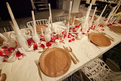Another communal table, decorated by HOK, CCI, and Knoll Textures, also eschewed linens. The white tabletop was covered in melted wax that had apparently dripped off tall white candles decking the table. Red rose petals were also scattered.