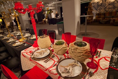 A red thread, symbolizing the fight against AIDS, ran through several of the communal tables at this year's event. At a table designed by Kimberle Winzeler of Pauline Grace, red thread was wrapped around a tall candelabra.