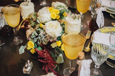 Bouquets of white, deep red, and yellow flowers punctuated the center of the dinner tables in between the tall pillar candles running the length of them.