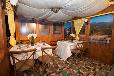 Another Diffa table, from Leopardo by VOA, recalled a Moroccan train car with wooden tables, topped with Moroccan tea glasses, which stood beside windows that appeared to reveal passing scenery.