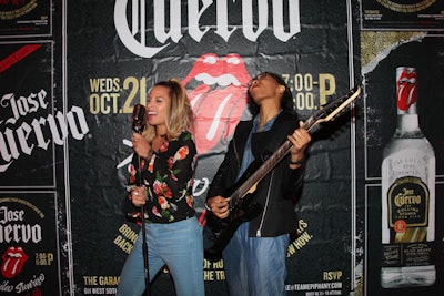 Guests posed at the photo booth station with guitar and microphone props at the Team Epiphany-produced event.