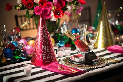 Magnolia Bluebird Design & Events created a bright, colorful dinner setting with festive hats and individual bottles of champagne for a new-year party.