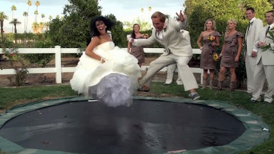 Bride and groom on a trampoline.