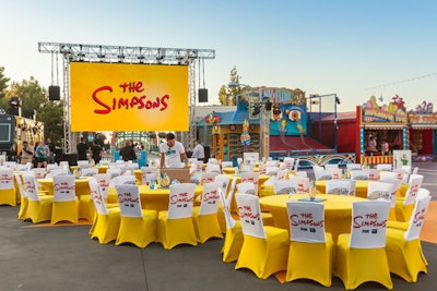 Bold yellow spandex and custom logo slipcovers covered the V.I.P. tables at Fox’s 27th season premiere of The Simpsons in September 2015, which was held at the Krustyland area of Universal Studios in Los Angeles.