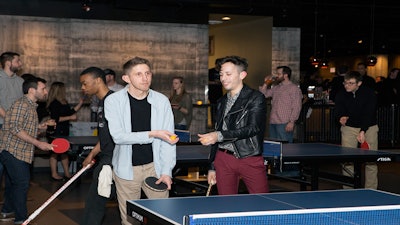Doubles! Models battle it out in a game of ping pong.
