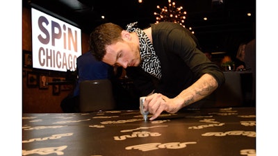 Chicago artist Lefty draws on a ping pong table at SPiN Chicago’s grand opening party.