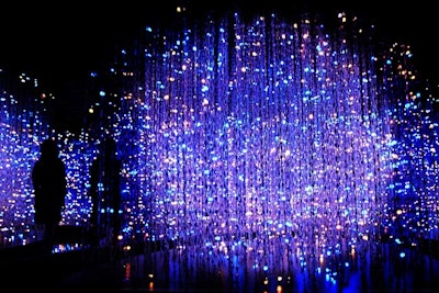To create 'Crystal Universe,' Teamlab installed LED lights in a three-dimensional space to create the illusion of an infinite number of light particles. Viewers can interact with the installation via smartphone: they swipe their phones while facing the installation to add various 'universe elements' to the piece.
