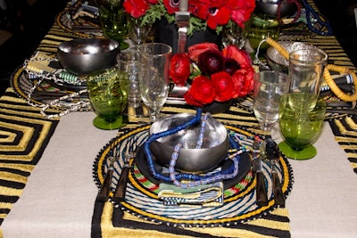 Architectural Digest's table settings included tribal-inspired bamboo mats, printed napkins, and napkin rings from Dransfield & Ross, with beechwood-stained black flatware by Ralph Lauren Home.