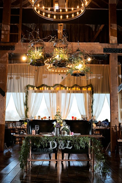 Birdcages entwined with vines hung above the couple’s table at a wedding designed by the JDK Group.