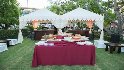 An appetizer table and bar tents in the Park at the Grove for Qatar Airways' Los Angeles International Airport launch party