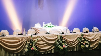 Special on-stage lighting illuminates the attractive head table.
