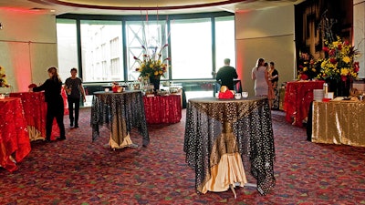 Set up highboy tables with custom linens in movie theater lobbies and hallways.
