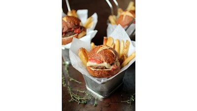 Miniature burger with tomato jam, brie, and fries in a fry basket