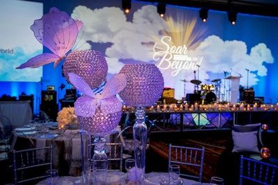 After the cocktail hour and silent auction, guests moved into a separate ballroom for the dinner program. Inspired by the celestial 'Soar Beyond' theme, designer Rishi Patel of HMR Designs incorporated butterflies and images of sunshine and clouds into the decor.