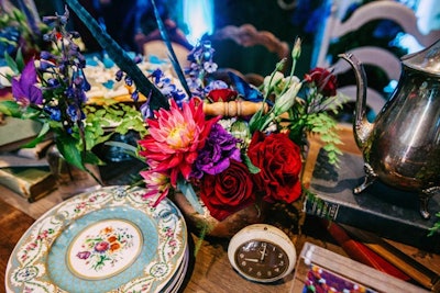 The multicolored arrangements in red and purple added dimension alongside the heavily patterned china. Teapots, books, and clocks also tied into the Alice in Wonderland theme.