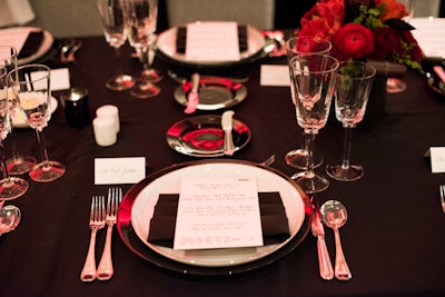 The elegant black table settings featured calligraphed dinner menus personalized for the special occasion, which served as a keepsake for the evening.