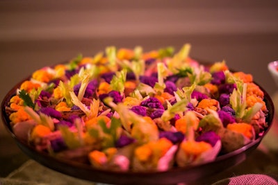 A “living garden” station included glass bowls with black pepper and quinoa-feta soil, held together by pureed fig, and preserved lemon-dipped baby hearts of romaine. The station also featured a glass centerpiece with herb-citrus marinated baby beets, carrots, scallions, and baby radishes in soil made from dried fruit, nuts, pumpernickel, pumpkin seeds, dried Porcini mushrooms, olive paste, and hazelnut oil. Another nature-inspired offering at the event was a roasted mushroom “forest” with kale pesto ground with cut wheatgrass, all presented in baby flower pots.