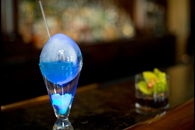 Lit with LED lights in customizable colors, the Peacock Egg cocktail at Peacock Alley in the Waldorf Astoria Orlando is served in a hollow egg-shaped ice cube, containing lavender syrup, blue Curacao, Bombay Sapphire gin, and fresh lemonade.