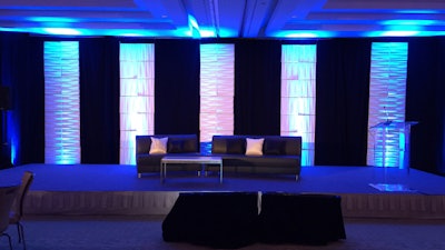 Corporate forum staged setting with lighted pillars and podium.