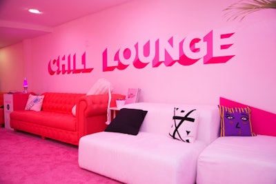 The upstairs lounge area featured hot pink and white furniture, a cocktail bar, and a charging station.