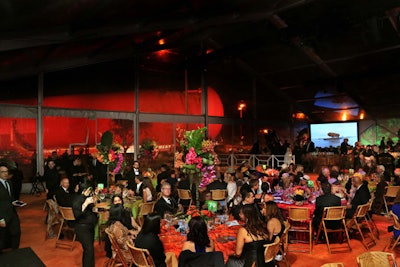 Guests dined in the clear tent structure, with the illuminated tank providing a dramatic backdrop outside.
