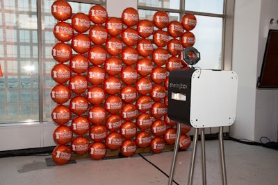 A wall of orange helium balloons featuring the No Kid Hungry logo served as the backdrop for the event's main photo booth.