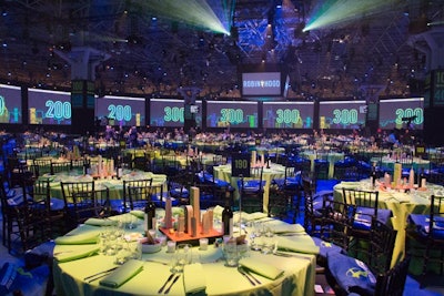 A ring of large screens lined the perimeter of the room. As guests entered the dining room, numbers on the screens and color-coded tableclothes helped them find their tables.